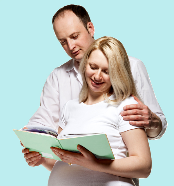 Pregnant couple looking at course material.